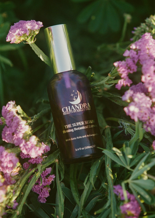 Bottle of THE SUPER SERUM nestled in flowers