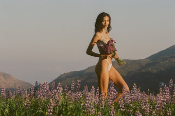 Kelly Gale, portrait in field of lavender holding a bouquet, in lingerie