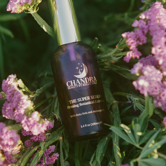 Bottle of THE SUPER SERUM nestled in flowers